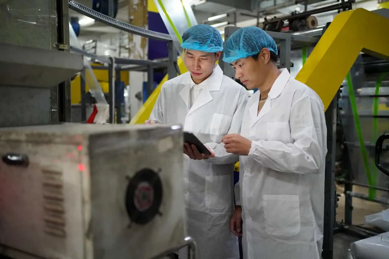 無塵環境中作業員檢視塑膠射出工廠製程｜碩朗塑膠射出工廠