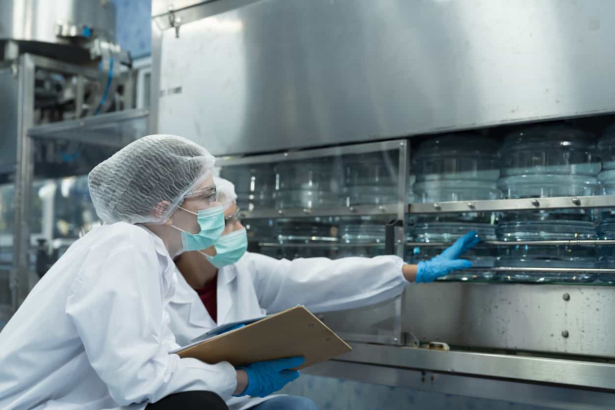 技術人員穿戴防護裝備於塑膠射出工廠檢查瓶桶生產｜碩朗塑膠射出工廠