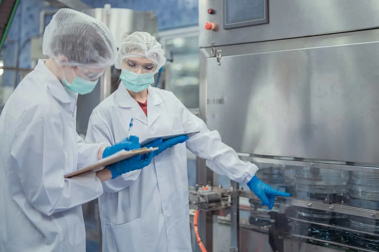 作業員觀察瓶桶射出設備並記錄製程數據｜碩朗塑膠射出工廠