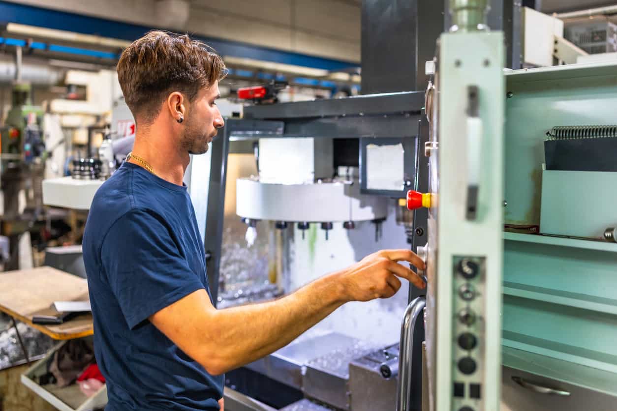 技術人員正在塑膠射出工廠的 CNC 機台進行程式操作，確保模具與產品達到高精度的生產標準。