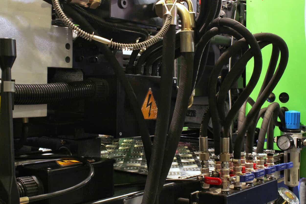 塑膠射出工廠注塑設備內部油壓管線與控制系統的複雜結構特寫